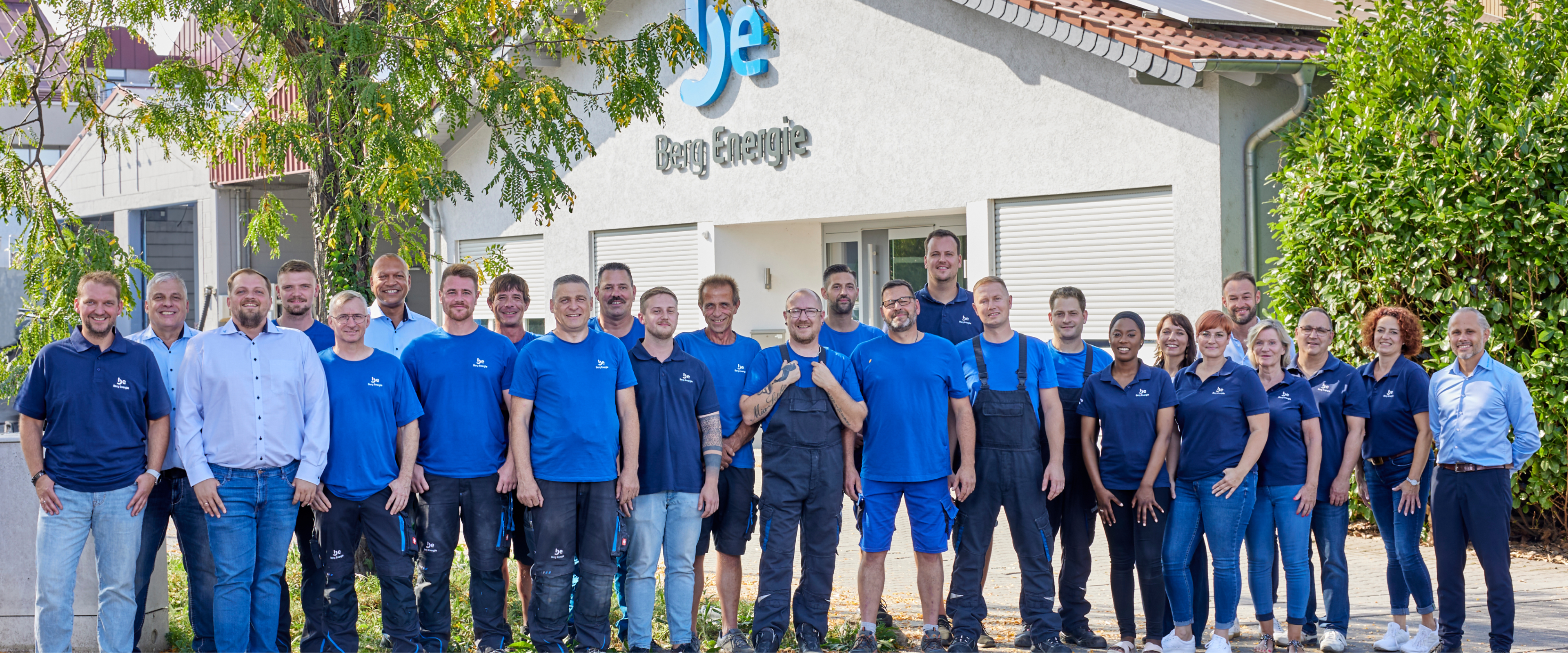 Gruppenbild des Berg-Energie-Teams vor dem Firmengebäude mit Logo